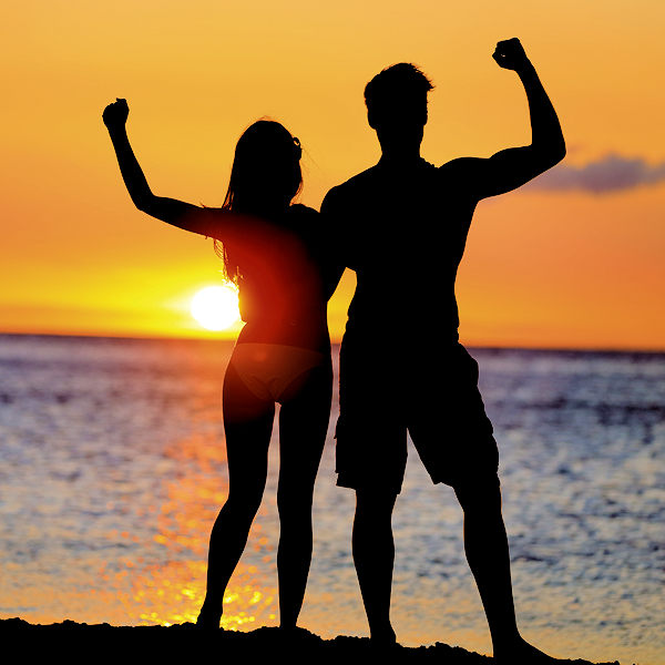 couple on beach with their fists up